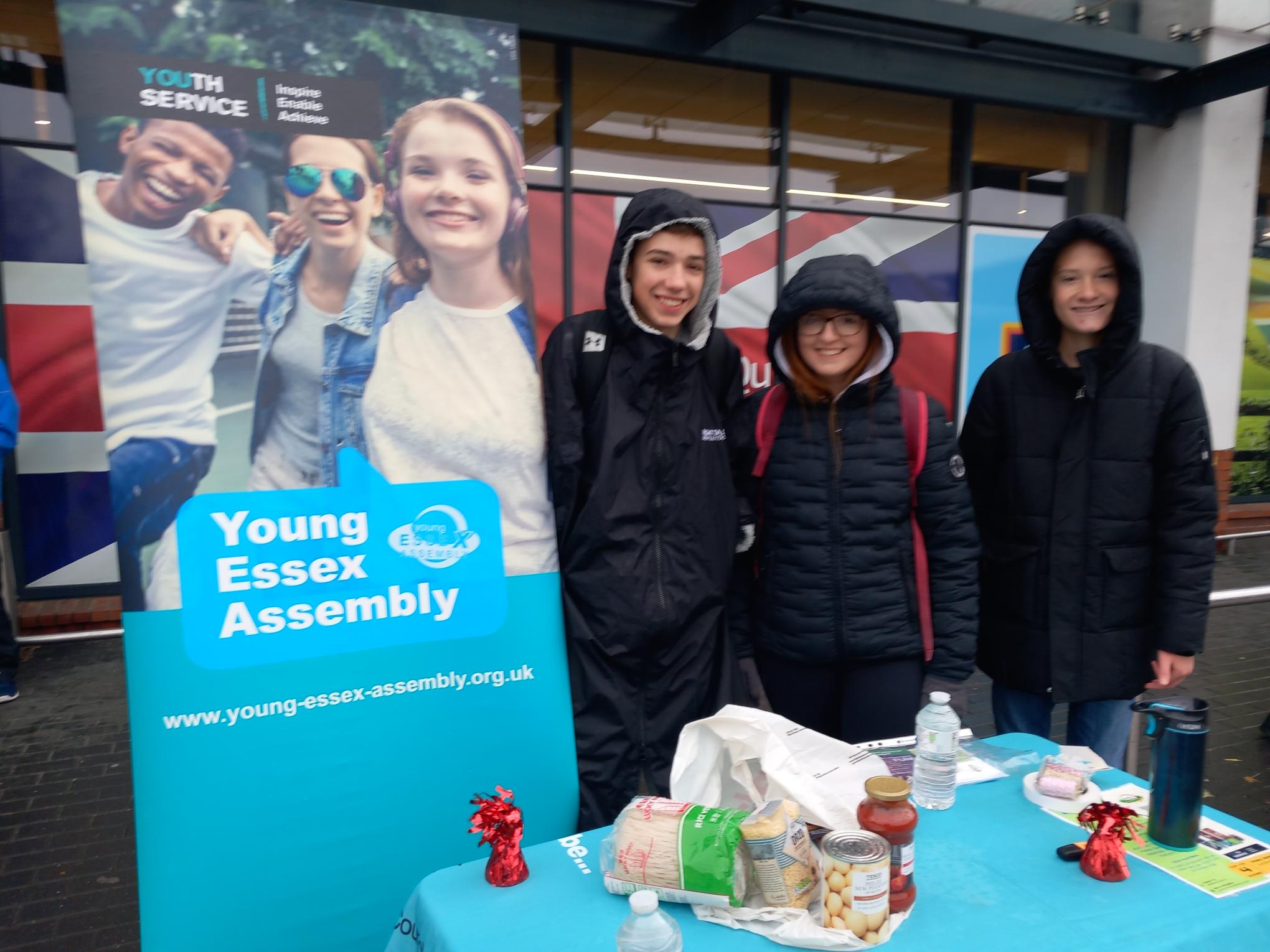 Young people standing by a table displaying food items